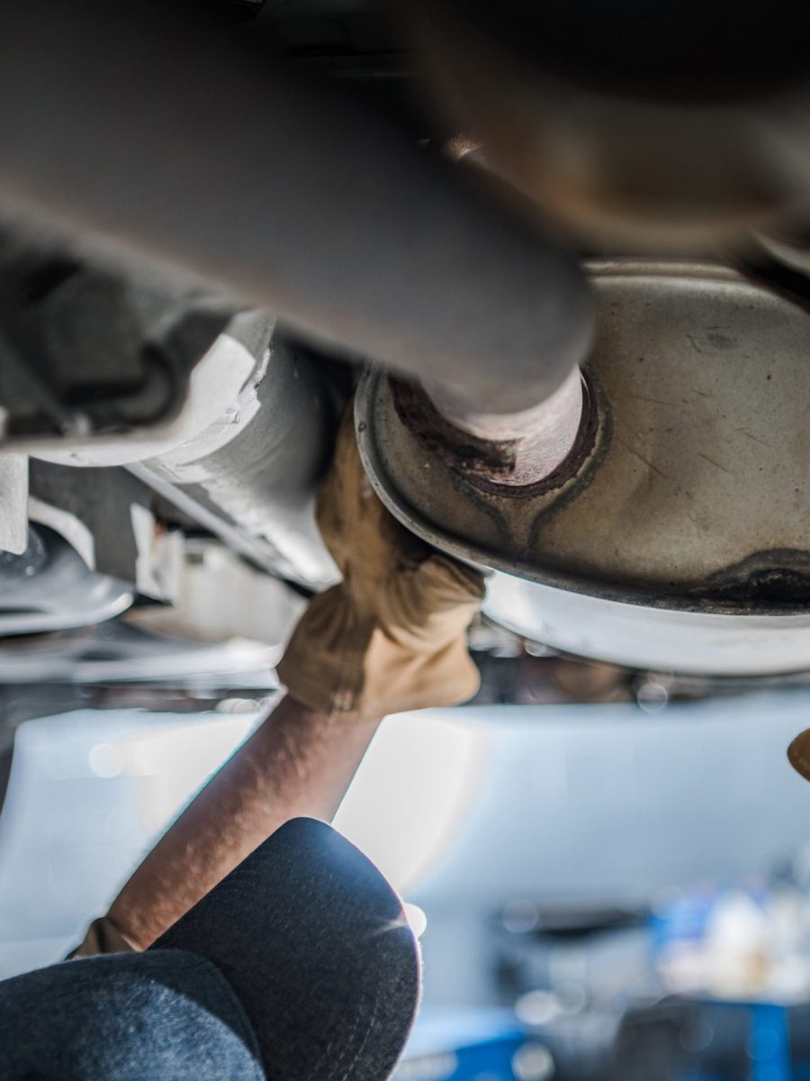 Mechanic Inspecting Vehicle's Catalytic Converter During Scheduled Car Exhaust System Check. Automobile Maintenance Theme.